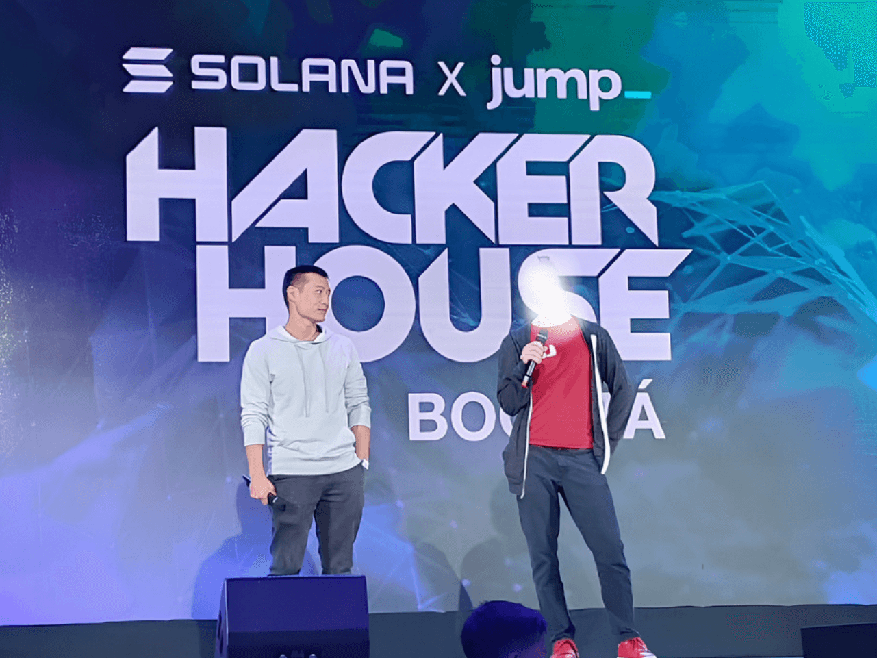 Danny Lim on stage at the Solana Hacker House hackathon in Bogotá, Colombia, presenting Kaizen Corps' product to the audience