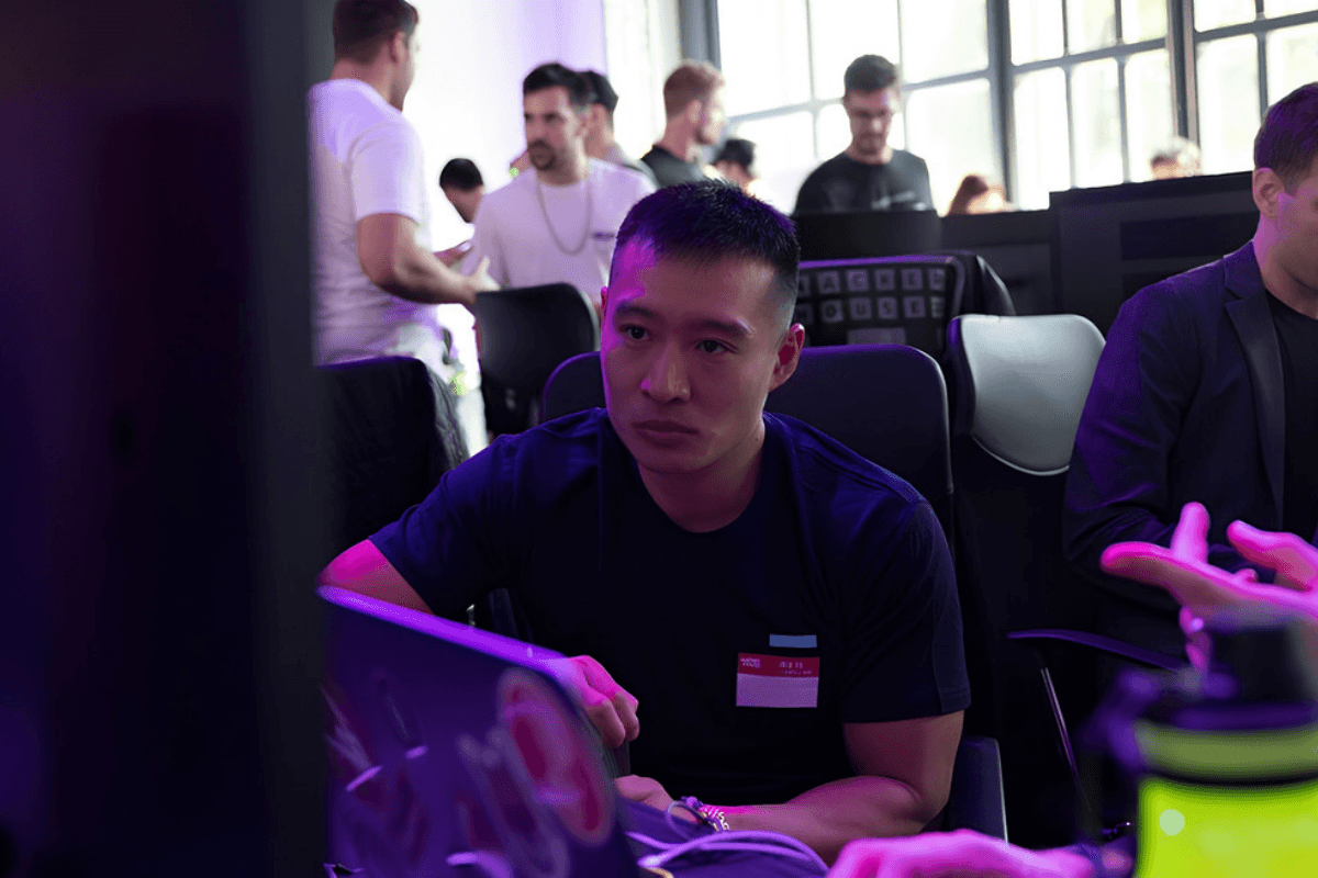 Danny Lim heads-down at a laptop building an app during Solana Breakpoint in Lisbon, Portugal, while working with Kaizen Corps